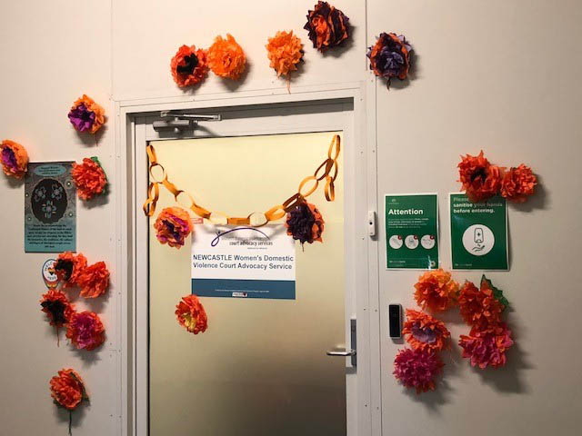 NWDVCAS door decorated for 16 Days of Activism with orange and purple bunting.